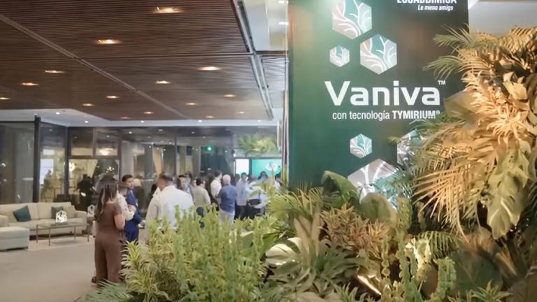 Stand de Vaniva con plantas decorativas y gente conversando en una feria interior